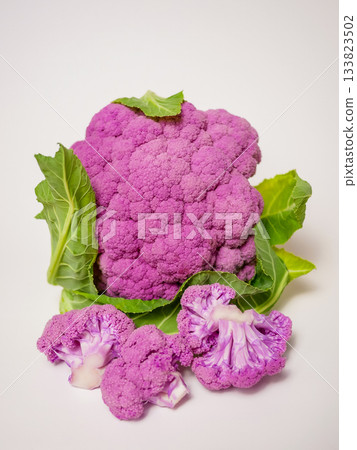Cut Purple Cauliflower Florets with Leaves on White Background Cut Purple Cauliflower Florets with Leaves on White Background 133823502