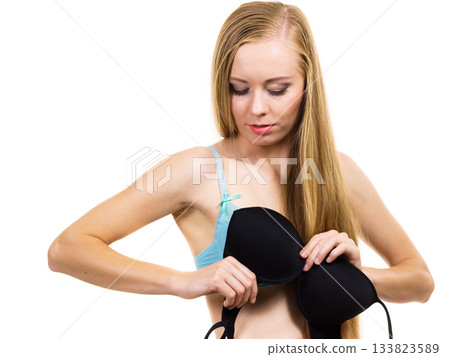Woman trying on black bra Woman trying on black bra 133823589