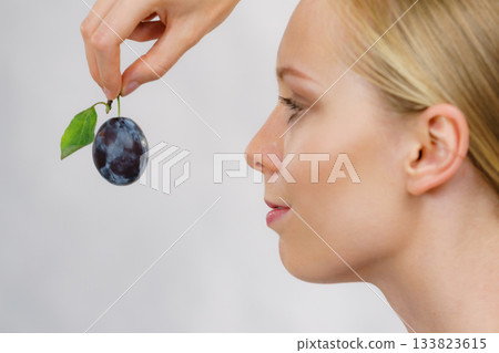 Girl holds plum fruit Girl holds plum fruit 133823615