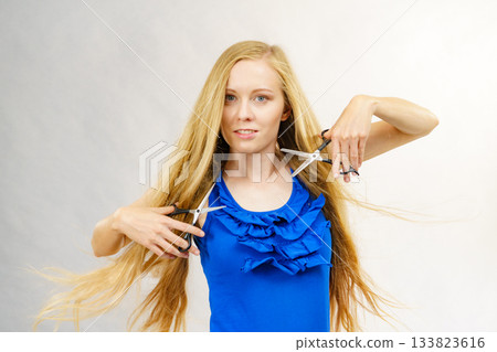 Girl with scissors for haircutting Girl with scissors for haircutting 133823616