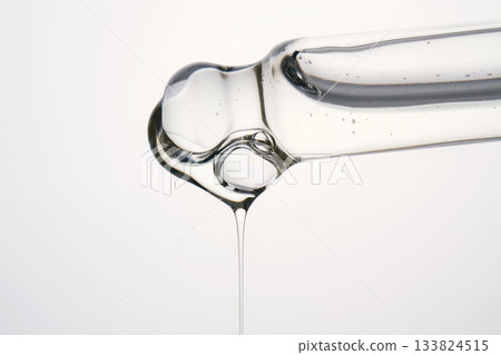 Cosmetic pipette dispensing transparent serum drop with bubbles Cosmetic pipette dispensing transparent serum drop with bubbles 133824515