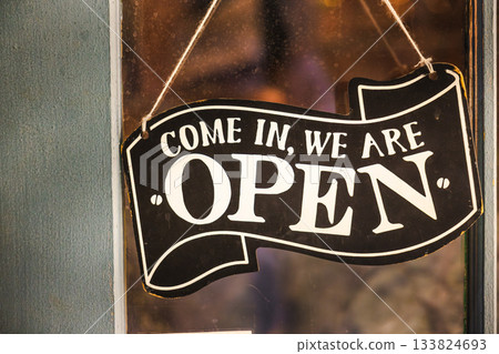 Vintage open sign hanging on a shop door with warm evening light in Toronto. Vintage open sign hanging on a shop door with warm evening light in Toronto. 133824693