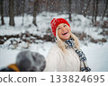 Happy elderly woman smiling outdoors in snowy weather. 133824695