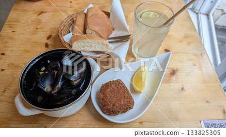 Steamed mussels, croquette, limeade on the table 133825305