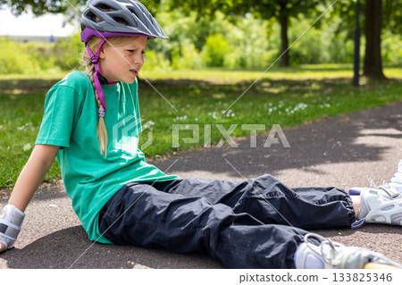 Portrait upset child sits floor roller skate small accident, showing discomfort and emotional reaction to fall. Sunny park setting contrasts tense moment vulnerability safety need support Portrait upset child sits floor roller skate small accident, showing discomfort and emotional reaction to fall. Sunny park setting contrasts tense moment vulnerability safety need support 133825346