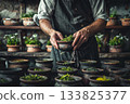 Experienced European chef carefully blends aromatic herbs into a fasting tea, capturing the essence of wellness and tradition in a serene kitchen setting with natural tones. 133825377