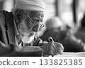 An Arabic senior listens attentively during a financial seminar, jotting down notes with focus. The expression on his face reflects deep engagement and a desire to learn and plan effectively. 133825385