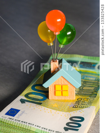 Colorful miniature house on euro banknotes symbolizing homeownership dreams and financial growth Colorful miniature house on euro banknotes symbolizing homeownership dreams and financial growth 133825428