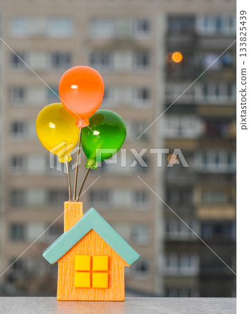 Miniature house with colorful balloons symbolizing dreams, hope, and the desire for your own home Miniature house with colorful balloons symbolizing dreams, hope, and the desire for your own home 133825439