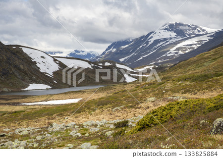 Hiking in Jotunheimen National Park near Bygdin hotel offers stunning views of Synshorn mountain and surrounding landscapes 133825884