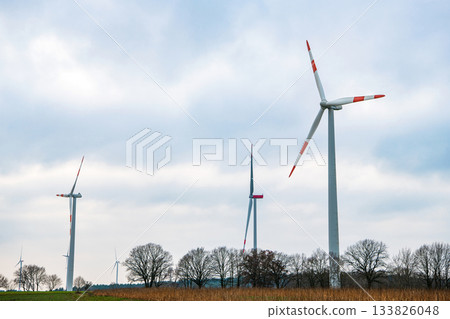 Windmill in rural autumn area. Offshore wind park. Wind turbines farm. Alternative renewable energy generation. Green energy concept. Wind mill for renewable electric energy production Windmill in rural autumn area. Offshore wind park. Wind turbines farm. Alternative renewable energy generation. Green energy concept. Wind mill for renewable electric energy production 133826048