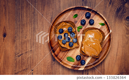 rye bread with peanut paste and fresh blueberries, top view, no people, 133826364