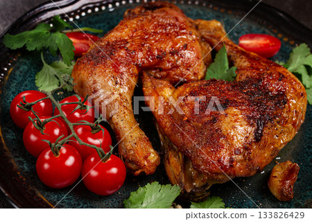 grilled fried chicken legs, served with fresh cherry tomatoes and herbs, on a plate, homemade, no people, 133826429