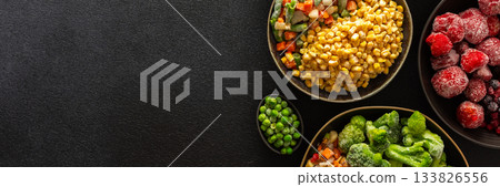 A variety of frozen veggies and fruits displayed in plates, set on a dark background, symbolizing the preparation and preservation of summer harvest for winter use, banner A variety of frozen veggies and fruits displayed in plates, set on a dark background, symbolizing the preparation and preservation of summer harvest for winter use, banner 133826556