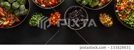 Frozen fruits and vegetables in plates, against a dark backdrop, reflecting the seasonal process of storing fresh produce for the colder months, banner Frozen fruits and vegetables in plates, against a dark backdrop, reflecting the seasonal process of storing fresh produce for the colder months, banner 133826631