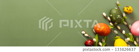 Brightly colored Easter eggs are displayed alongside spring branches, evoking a cheerful atmosphere perfect for the holiday. This festive arrangement celebrates seasonal joy and renewal, banner 133826637