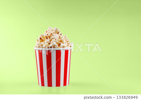 Classic red striped popcorn cardboard cup on Green background 133826949