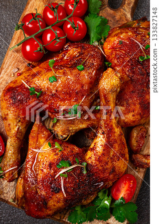 grilled fried chicken legs, served with fresh cherry tomatoes, and herbs, on a wooden chopping board, homemade, no people, 133827148
