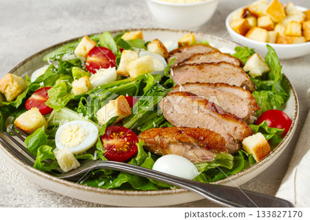 Caesar salad, with duck breast, on a light plate, on a light background, homemade, no people, 133827170