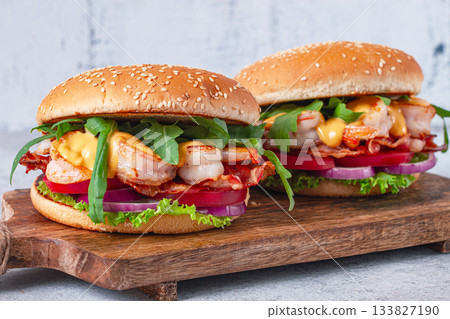 Shrimp burgers with fresh ingredients are served on a wooden board in a bright kitchen, Shrimp burgers with fresh ingredients are served on a wooden board in a bright kitchen, 133827190