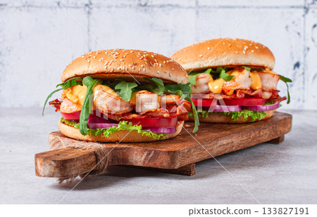 Shrimp burgers with fresh ingredients are served on a wooden board in a bright kitchen, Shrimp burgers with fresh ingredients are served on a wooden board in a bright kitchen, 133827191