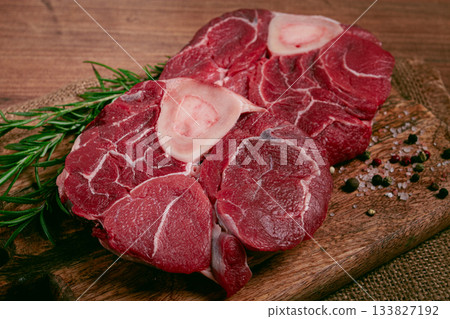 knuckle on the bone, raw meat for ossobuco, on a wooden chopping board, with a sprig of rosemary, and spices, top view, no people, knuckle on the bone, raw meat for ossobuco, on a wooden chopping board, with a sprig of rosemary, and spices, top view, no people, 133827192