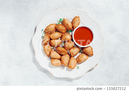 Fried mini chebureks, with sauce, on a decorative plate, hard light, no people, 133827212