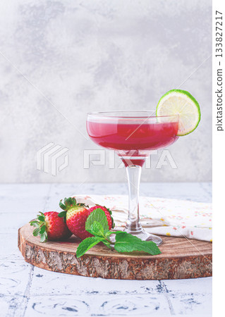 Refreshing cocktail in an elegant glass with lime and strawberries, sunshine, no people, Refreshing cocktail in an elegant glass with lime and strawberries, sunshine, no people, 133827217
