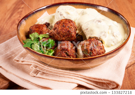 Swedish meatballs in cream sauce, plate on a wooden table, homemade, no people, 133827218