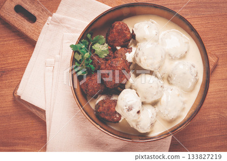 Swedish meatballs in cream sauce, plate on a wooden table, homemade, no people, 133827219
