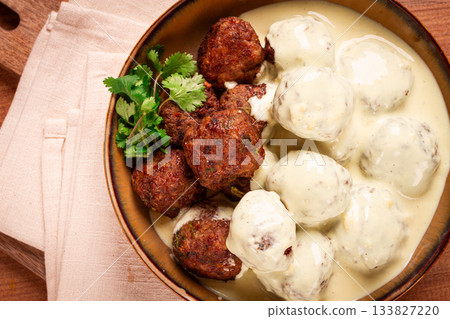 Swedish meatballs in cream sauce, plate on a wooden table, homemade, no people, 133827220