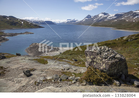 Stunning view of Lake Bygdin surrounded by mountains in Jotunheimen National Park, Norway during a clear day Stunning view of Lake Bygdin surrounded by mountains in Jotunheimen National Park, Norway during a clear day 133828004