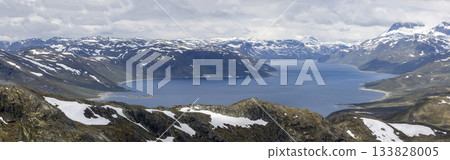 Majestic Lake Bygdin surrounded by mountains in Jotunheimen National Park on a cloudy day Majestic Lake Bygdin surrounded by mountains in Jotunheimen National Park on a cloudy day 133828005
