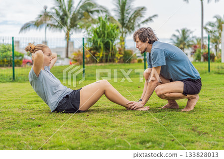 A man and woman working out together in a sunny park, staying active and motivated as a team. Outdoor fitness, wellbeing, healthy lifestyle, exercise routine and relationship bonding concept A man and woman working out together in a sunny park, staying active and motivated as a team. Outdoor fitness, wellbeing, healthy lifestyle, exercise routine and relationship bonding concept 133828013