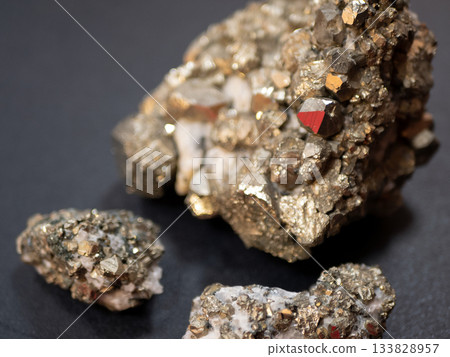 Natural pyrite crystals. Metallic cubic formations with geological texture and golden luster 133828957