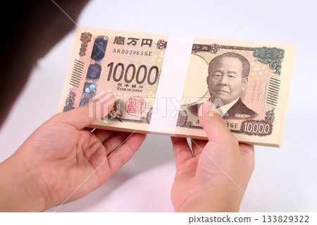 孩子的手拿著一疊鈔票 孩子的手拿著一疊鈔票 133829322