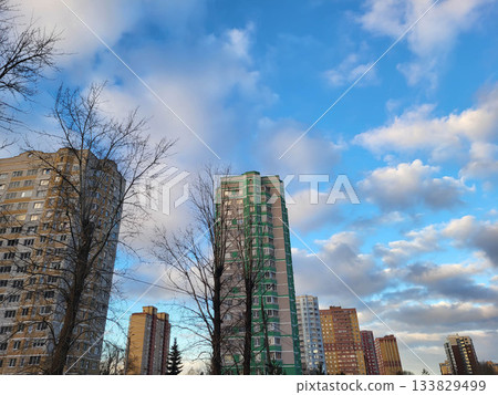 On a sunny autumn day, modern buildings stand tall against a blue sky with clouds. On a sunny autumn day, modern buildings stand tall against a blue sky with clouds. 133829499