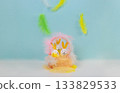 On a blue background, falling feathers and Easter eggs with bunny ears in a basket of feathers. Easter concept. 133829533