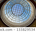 A round glass decorative ceiling with a modern design against a blue sky background. 133829534