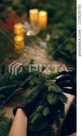 Artisans meticulously assemble holiday greenery and ornaments 133829785