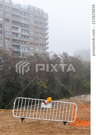 White brick fence on a ground dug out on a foggy day with tall buildings in the background White brick fence on a ground dug out on a foggy day with tall buildings in the background 133829856
