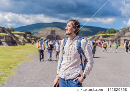 Male tourist posing in front of the pyramids of Teotihuacan in Mexico, enjoying sightseeing, cultural heritage, and travel adventure Male tourist posing in front of the pyramids of Teotihuacan in Mexico, enjoying sightseeing, cultural heritage, and travel adventure 133829868