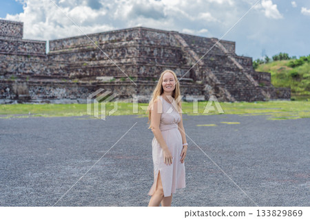 Female tourist standing in front of Teotihuacan pyramids in Mexico, enjoying sightseeing, adventure, and cultural heritage. Travel, tourism, and exploration concept 133829869
