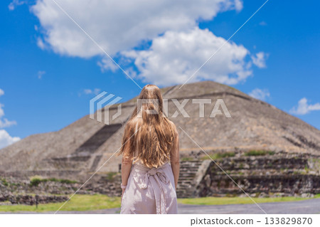 Female tourist standing in front of Teotihuacan pyramids in Mexico, enjoying sightseeing, adventure, and cultural heritage. Travel, tourism, and exploration concept Female tourist standing in front of Teotihuacan pyramids in Mexico, enjoying sightseeing, adventure, and cultural heritage. Travel, tourism, and exploration concept 133829870