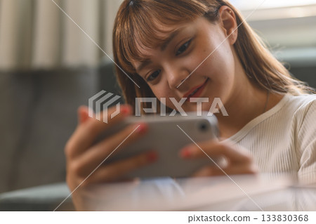 A girl operating a smartphone in landscape orientation A girl operating a smartphone in landscape orientation 133830368