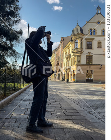 Photographer With Camera On Historic City Street Capturing Urban Architecture and Moments 133830631