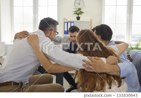 Group of business people putting hands on each others shoulders 133830643