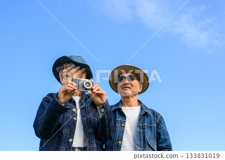 Senior couple holding a camera Senior couple holding a camera 133831019