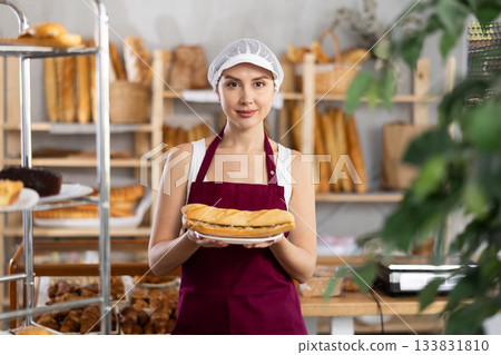 Smiling woman baker offers to buy fresh delicious bocadillo 133831810