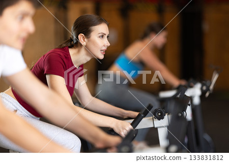 Woman exercising on an exercise bike Woman exercising on an exercise bike 133831812
